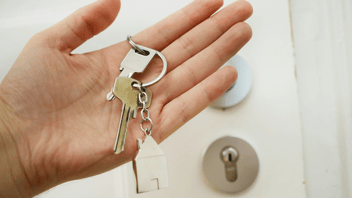 mão de uma pessoa segurando a chave da casa própria